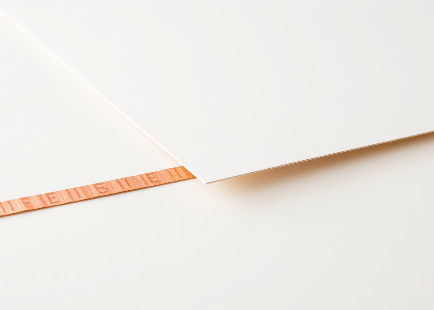 Sheets of paper with a single copper edge, representing the group's publishing platforms